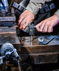 Hands using a Reversible Ratcheting T Handle Tap Wrench for precise automotive threading with a smooth reverse action.