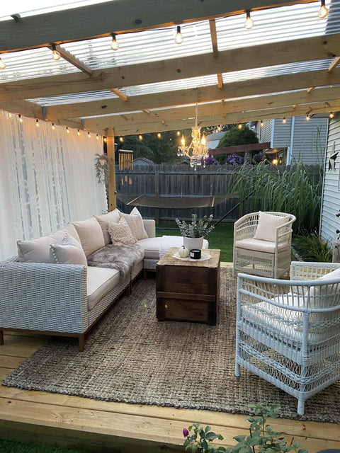 Outdoor space with Plug In Crystal Swag Chandelier With Three Lights, wicker furniture, and ambient lighting under a pergola.