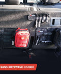 Car interior with Tech Panel Small 2.5 By 9.5 Inch Universal Vehicle MOLLE Organizer holding pouches and gear on back seat.