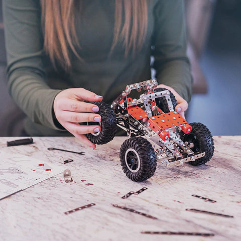 Hands building a car model from Beast Mode Erector Set Metal Model Kit For Adults Teens And Advanced Kids Build Cars Planes And Excavators