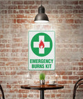 Emergency Burn Care Sign 8x12 Inches Aluminum Warning Plate for indoor use displayed on brick wall in cafe setting.