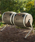 Double Bin Rotating Composter With Two 50 Gallon Barrels For Nonstop Composting in garden setting, side view