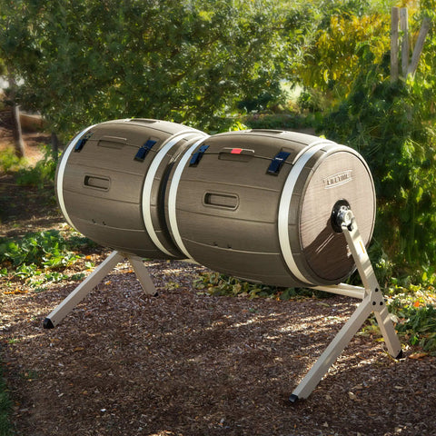 Double Bin Rotating Composter With Two 50 Gallon Barrels For Nonstop Composting in garden setting, side view