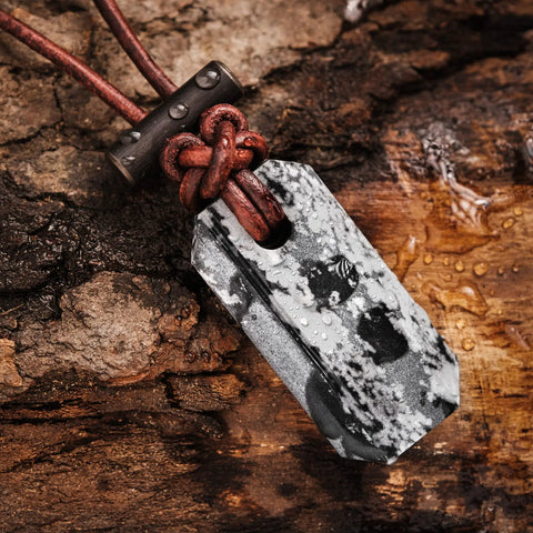 Close-up of Viking Spark Whetstone Sharpener And Fire Starter Necklace on wooden surface displaying ferrocerium rod and pendant.