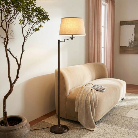 Caden LED Floor Lamp With Swing Arm Tall Bronze Standing Light in cozy living room next to tan sofa and potted plant