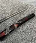 Close-up of a sword from the Red 3 Piece Samurai Sword Set With Display Stand Katana Collection, focusing on black and red accents.