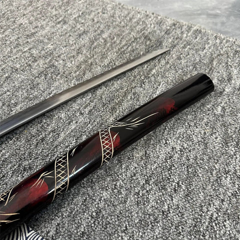 Close-up of a sword from the Red 3 Piece Samurai Sword Set With Display Stand Katana Collection, focusing on black and red accents.