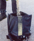 Spyker 25Lb Bag Spreader With Material Viewing Window And Easy Calibration System on pavement with person pouring granules