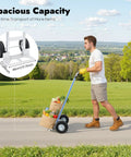 Heavy Duty Hand Truck With 500 Pound Capacity And 10 Inch Rubber Wheels transporting bags of groceries on a pathway outdoors.