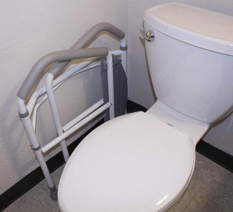 Hassel Free Folding Toilet Safety Frame And Super Solid Portable Bathroom Handrail leaning against a toilet for easy access.