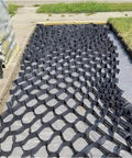 Gravel Driveway Stabilizer Grid With Drainage Holes installed on driveway surface, HDPE material, 40x40 cm grid, eco-friendly.
