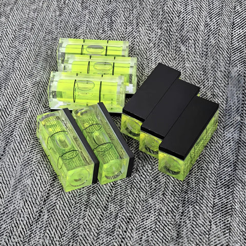 Magnetic Small Bubble Levels, multifunctional folding spirit level in bright yellow and black, arranged on a textured surface.
