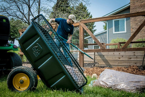 Heavy Duty Lawn And Garden Trailer With 900 Lb Capacity 15 Cu Ft Poly Tub Tilt And Pivot Frame Sealed Bearings in use by gardener