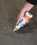Hand applying Pre Mixed Tile Grout For Walls And Floors White 5.5 Oz Pro Quality With Excellent Adhesion Easy To Use And Water Clean Up Ideal For Ceramic And Mosaic Tiles Adheres To Tile Masonry Wood And Wallboard Made In USA to floor tiles