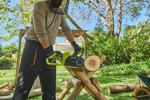 Hella Smooth 18V Brushless Battery Chainsaw With 30Cm Oregon Bar in use cutting log on wooden support outdoors.