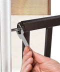 Hand tightening pressure mount bolt on Decorative Walk-Thru Baby And Pet Gate For Openings Up To 60 Inches, walnut wood and charcoal metal accents.