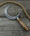 Hand Forged Athame Crescent Blade Sickle For Ritual Work And Herb Harvesting A Versatile Witchy Tool on wooden background with rope