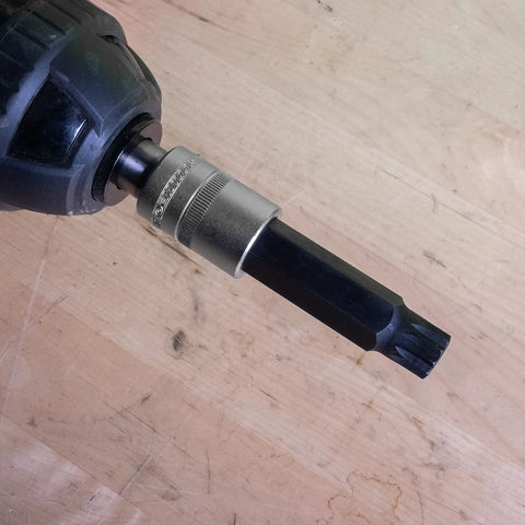 Close-up of a Long Triple Square Bit Set For Automotive Repairs, attached to a drill, showing magnetic retention and S2 steel