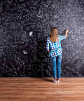 Person writing on a large chalkboard wall with equations using Chalkboard Paint Kit Two Pack Black Brush On Dope Finish Delivers Smooth Writable And Erasable Slate Like Surface For Interior Use On Non Porous Surfaces Like Chalkboards Tables Walls And Creative Decor