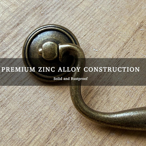 Vintage Bail Drawer Pull Set 4 Pack Antique Brass Cabinet Handles 3.75 Inch Center To Center For Dresser Cupboard Wardrobe And Kitchen Cabinets Classic Drop Design showing premium zinc alloy construction on wood surface.