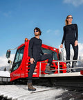 Men's Three Quarter Length Base Layer Tights For Skiing With Warmth worn by a person standing on a red snowcat in winter.
