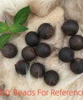 Round dark brown beads on a soft fur background with green leaves