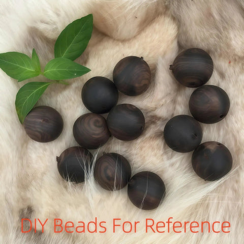 Round dark brown beads on a soft fur background with green leaves