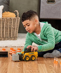 Child playing with Big Farm Skid Steer Set 1 16 Scale Lights And Sounds Construction Toy With Interchangeable Bucket And Forks indoors.