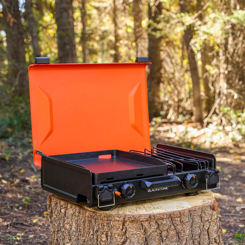 2364 12 By 14 Camping Griddle With Side Burner Nonstick Ceramic Titanium Coated Surface open on tree stump in forest