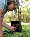 Person adjusting Air Strike Pellet Trap For 800fps Airguns With Interchangeable Silhouette Targets And Paper Target Compatibility Heavy Duty Steel Backdrop Catcher Black outdoors