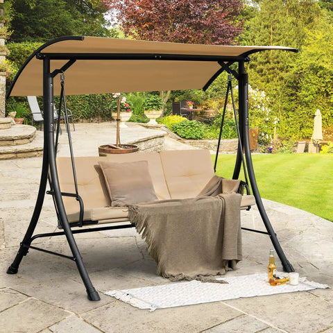 Three Person Porch Swing With Removable Cushions, Solid Steel Frame, beige canopy, set on a stone patio in garden.