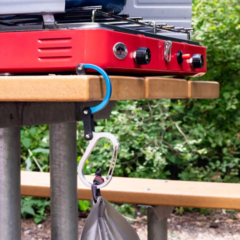 HeroClip Large Carabiner Clip And Hook For Camping, Backpacking, Garage Organization And Home Use, 3 In 1 Clip in use on picnic table
