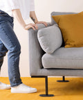 Person moving a gray sofa on Sixteen Piece 6 Inch Oval Furniture Sliders For Carpet Glide Heavy Sofas Chairs Tables And More Across Carpeted Floors With Ease Padded Moving Pads For Floor Protection No Scratches Mover Pack, showing ease of use on carpet.