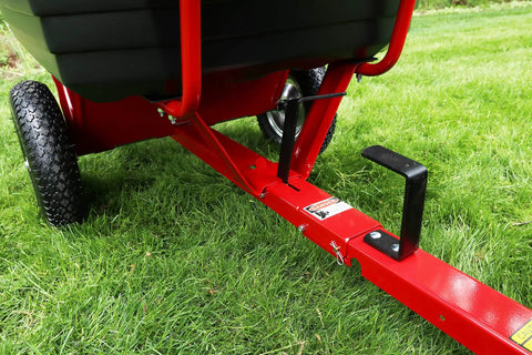 Close-up of the hitch and tire of Rock Solid Six Hundred Fifty Pound Poly Dump Cart For Tough Job Site Hauling.