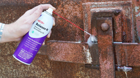 Stuck Bolts And Nuts Teflon Penetrant Aerosol 10 oz being sprayed on rusty metal hinge by hand for quick penetration