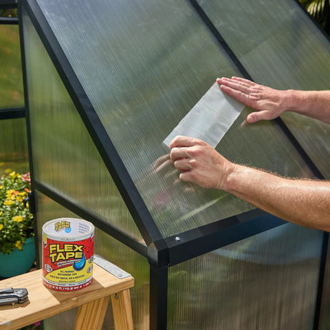 Person applying Thick Rubberized Waterproof Tape That Patches And Seals Leaks Like A Pro Anywhere Underwater Ready Indoor Outdoor Use Great For Roofs Plumbing Pools And RVs Clear 4 In By 5 Ft Pack Of 1 on greenhouse panel