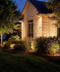 12V MR16 Adjustable Cowl Brass Accent Light for landscape lighting in Centennial Brass finish illuminating outdoor house garden scene