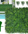 12 Pack 10x10 Inch Faux Boxwood Wall Panels For Indoor Outdoor Privacy Fencing Ivy Backdrop Garden Decor UV Resistant Four Layer Leaves Two Inch Height Covers About Eight Point Four Sq Ft showing greenery panel near pool.
