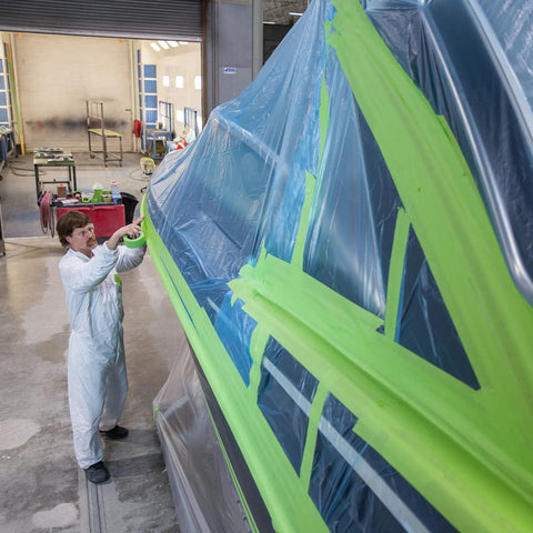 Person applying High Performance Green Masking Tape 401 Plus For Clean Paint Lines, Superior Adhesion, Easy Peel No Residue on vehicle
