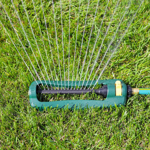 TurboTek Oscillating Sprinkler With 16 Precision Nozzles for Up To 2,800 Sq Ft on lawn, green and yellow design visible