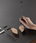 Hand using Slick Mini Electric Screwdriver 11 In 1 Cordless Drill Kit With 8 Bits for DIY wood project on black table