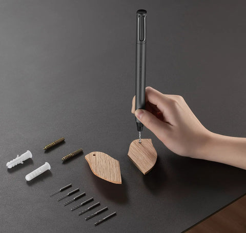 Hand using Slick Mini Electric Screwdriver 11 In 1 Cordless Drill Kit With 8 Bits for DIY wood project on black table