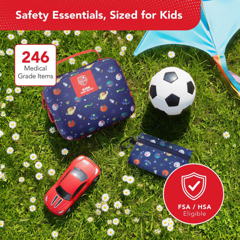 Kids First Aid Kit 246-Piece Bundle For Travel, Home, And Car Emergency Needs displayed on grass with toys and umbrella.
