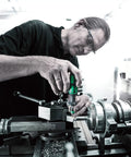 Person using Kraftform Series 7400 Adjustable Torque Screwdriver with Rapidaptor Quick Release Chuck for precise fastening on machinery.