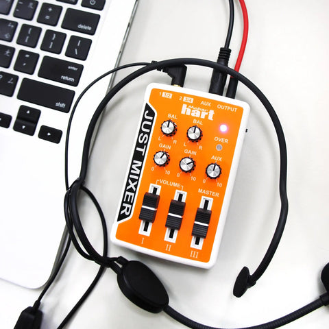 Portable Three Channel DJ Mixer For On The Go USB Or Battery Powered Pocket Audio Mixer With 3.5mm Inputs And Built In On Off Switch In Bright Orange For Quick Street Setup connected to a laptop and headphones.