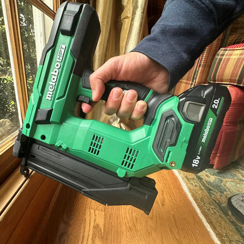 Person holding 18V MultiVolt Cordless Brushless Impact Driver And 18 Gauge Brad Nailer Combo Kit For Framing And Finishing.