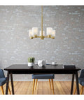 Five Light Indoor Chandelier In Champagne Brass Finish With Frosted Glass, hanging over a dining table against a brick wall.