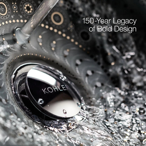 Close-up of Kohler drain with water flow, showcasing sleek metal design beneath clear surface, emphasizing 150-year legacy.