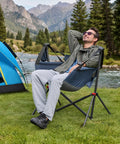 Man relaxing in a Hammock Camping Chair With Adjustable Backrest And Pillow Cup Holder, Heavy Duty 350 Lbs Oversized Swinging Chair by a river.