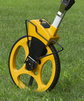 Rugged Pro 12 Inch Diameter Measuring Wheel Measures Up To 10,000 Yards With Brake And Reset Trigger on grass.